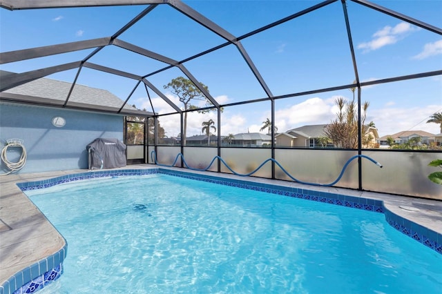 view of swimming pool with a patio area and glass enclosure