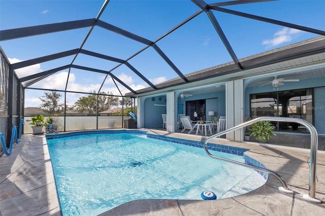 view of swimming pool with a patio, ceiling fan, and glass enclosure