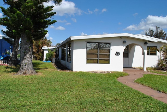 view of front facade with a front yard and central air condition unit