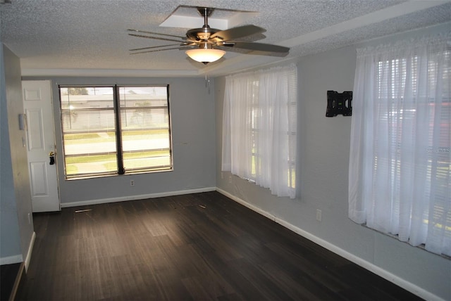 unfurnished room with ceiling fan, a textured ceiling, and dark hardwood / wood-style flooring