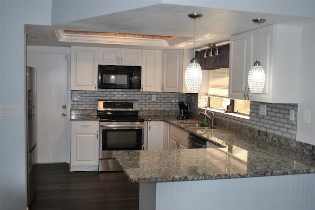 kitchen with hanging light fixtures, kitchen peninsula, white cabinets, a raised ceiling, and appliances with stainless steel finishes