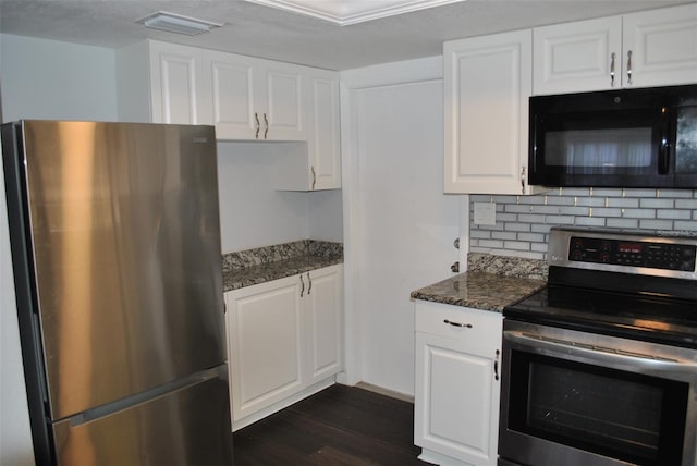 kitchen with stainless steel appliances, dark stone counters, dark hardwood / wood-style floors, and white cabinets