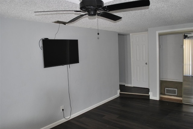 unfurnished bedroom featuring dark wood-type flooring, a textured ceiling, and ceiling fan