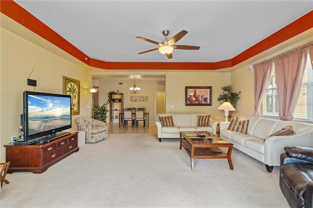 living room with light carpet and ceiling fan with notable chandelier