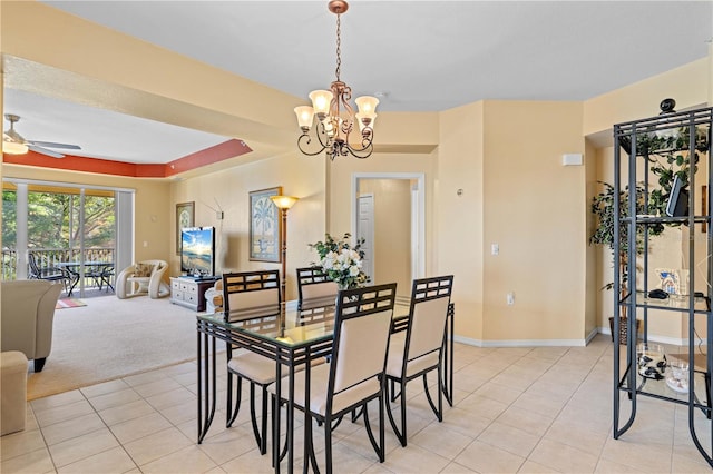 dining room featuring light colored carpet and ceiling fan with notable chandelier