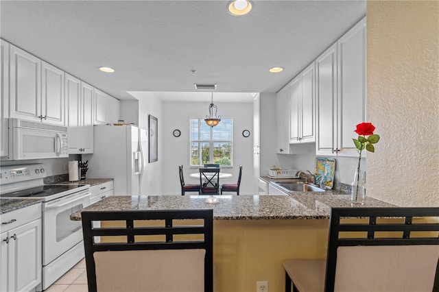 kitchen featuring kitchen peninsula, white cabinetry, and white appliances