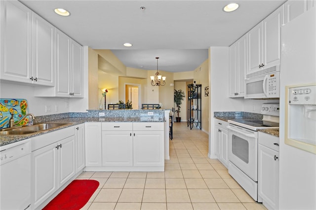 kitchen featuring white appliances, white cabinetry, decorative light fixtures, and kitchen peninsula