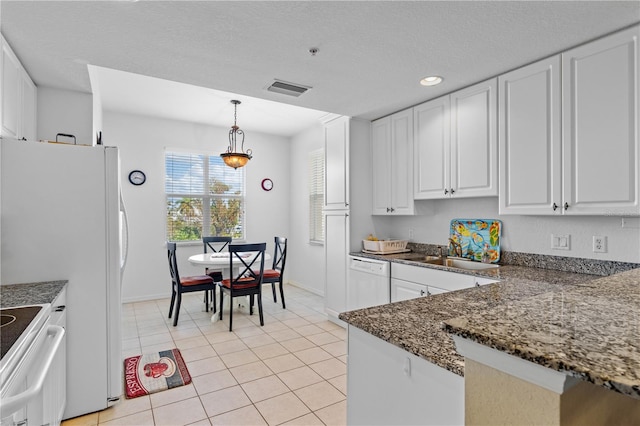 kitchen with sink, light tile patterned flooring, decorative light fixtures, white cabinets, and white appliances