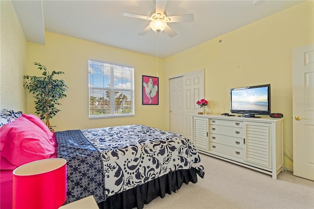 bedroom with a closet, ceiling fan, and light colored carpet