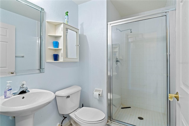 bathroom with a shower with door, sink, and toilet