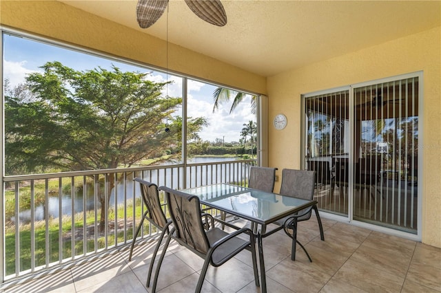 sunroom with a water view and ceiling fan