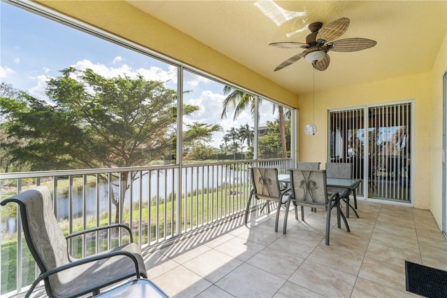 sunroom with a water view and ceiling fan