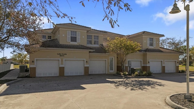 view of front of home with central AC unit and a garage