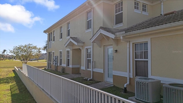 view of home's exterior with central AC and a yard