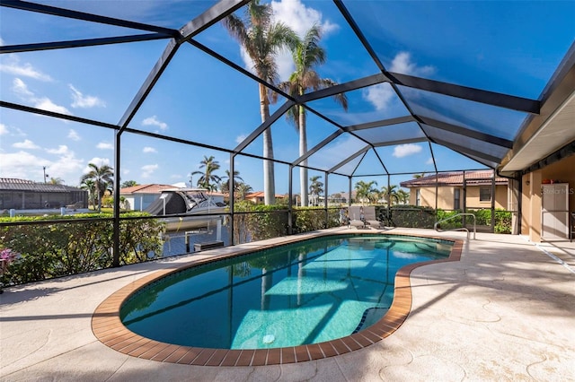 view of swimming pool featuring glass enclosure and a patio