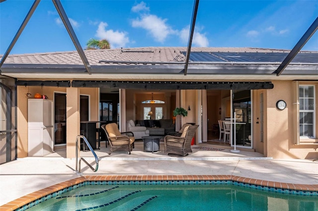 rear view of house with glass enclosure and a patio