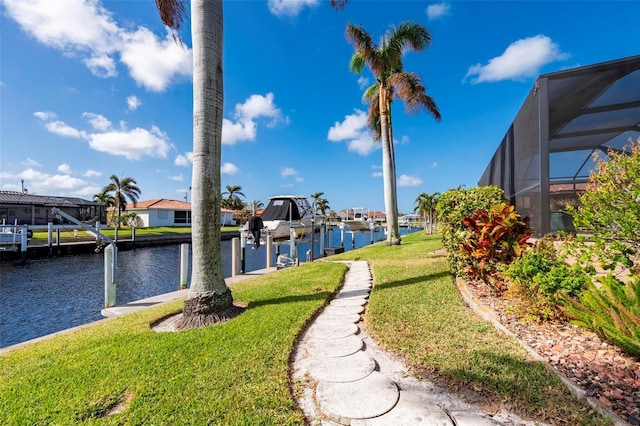 view of yard featuring glass enclosure, a dock, and a water view