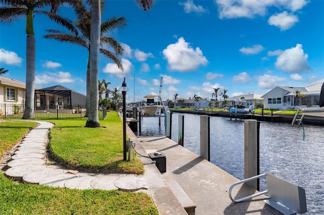 dock area with a lawn and a water view