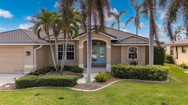 ranch-style home with a garage, a front lawn, and french doors