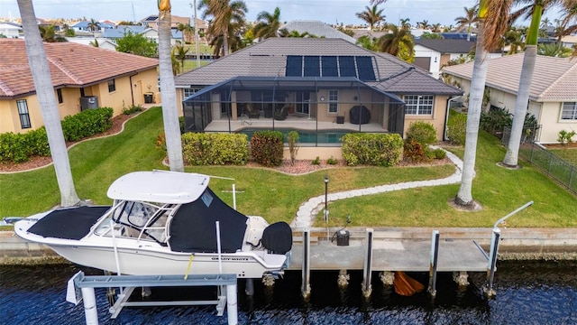 rear view of property featuring glass enclosure, a yard, and a water view