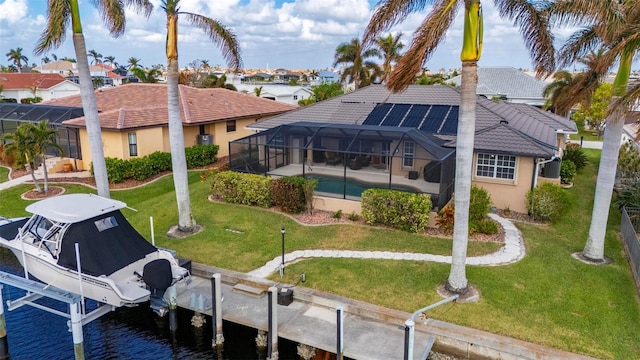 back of property with glass enclosure, a yard, and a water view