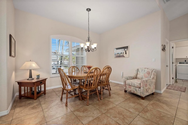 dining space featuring washer / clothes dryer, a chandelier, and light tile patterned flooring