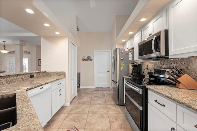 kitchen featuring light tile patterned floors, light stone countertops, white cabinetry, and appliances with stainless steel finishes