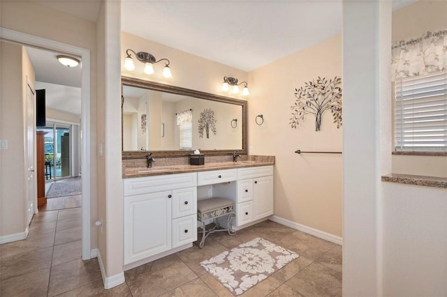 bathroom with tile patterned floors, a wealth of natural light, and vanity