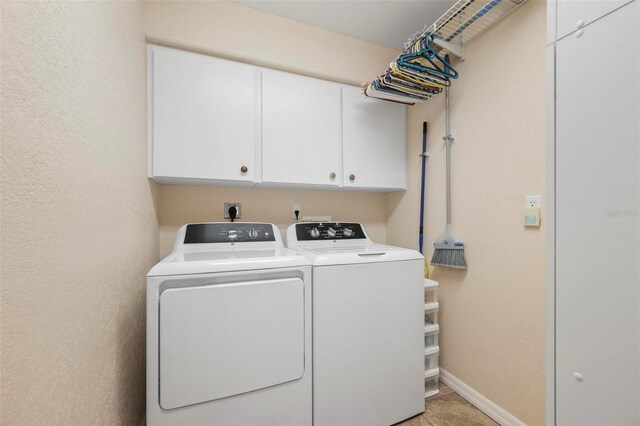 laundry area with cabinets, washer and clothes dryer, and light tile patterned flooring