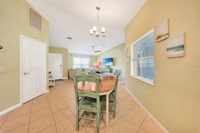 dining area featuring vaulted ceiling, light tile patterned flooring, and ceiling fan with notable chandelier