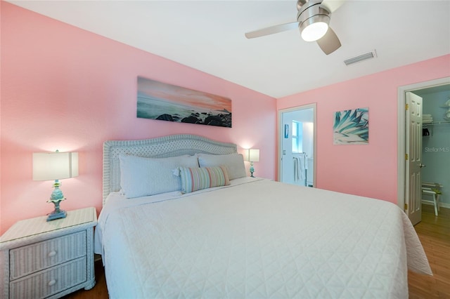 bedroom featuring ensuite bathroom, ceiling fan, a spacious closet, dark hardwood / wood-style flooring, and a closet