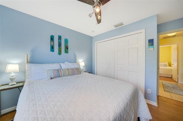 bedroom with ceiling fan, a closet, and wood-type flooring