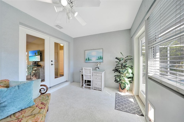 interior space with light carpet, french doors, and ceiling fan