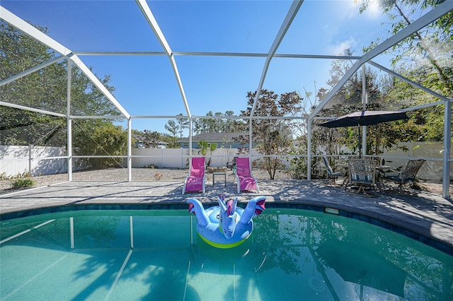 view of swimming pool with glass enclosure and a patio area