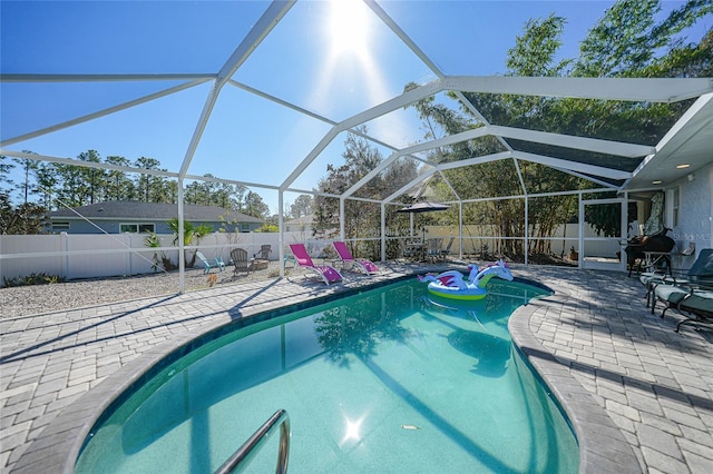 view of swimming pool with glass enclosure and a patio