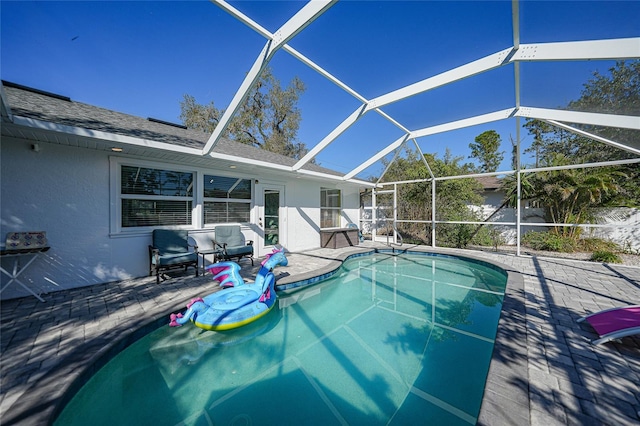 view of swimming pool with a patio area, an outdoor living space, and glass enclosure