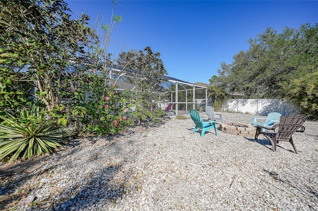 view of yard featuring a lanai and an outdoor fire pit