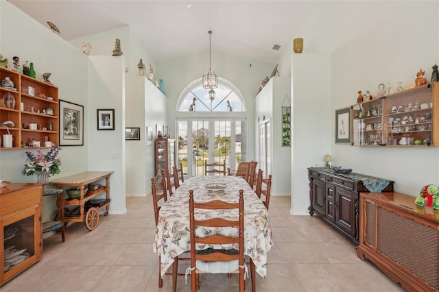 dining room featuring high vaulted ceiling, french doors, a notable chandelier, and light tile patterned flooring