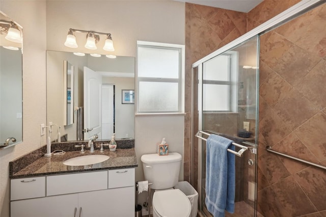 bathroom with walk in shower, vanity, and toilet