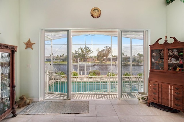 entryway with a water view, light tile patterned floors, and a wealth of natural light