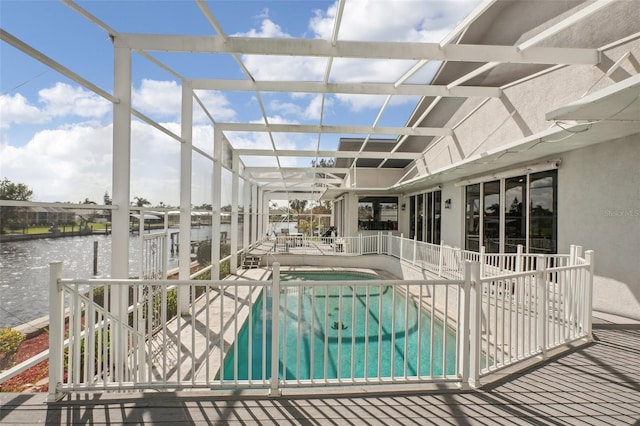 view of swimming pool with a patio area, a lanai, and a water view