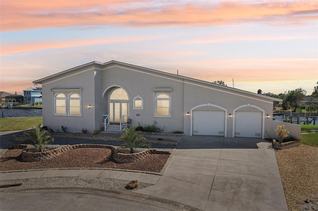 view of front of home with concrete driveway, a garage, and stucco siding