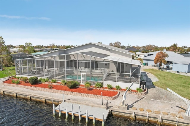 rear view of house with a patio area, a water view, and a lawn