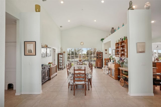 tiled dining area featuring high vaulted ceiling