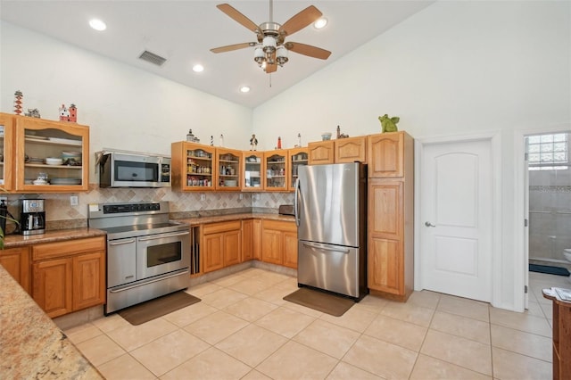 kitchen featuring high vaulted ceiling, backsplash, light tile patterned floors, and stainless steel appliances