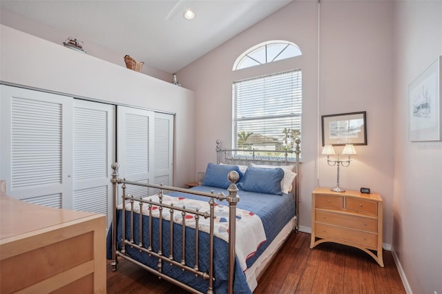 bedroom with a closet, vaulted ceiling, and dark hardwood / wood-style flooring