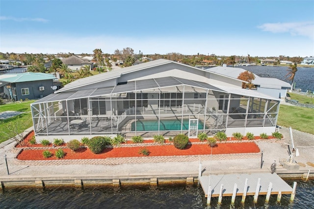 rear view of house featuring a water view, a patio, and glass enclosure