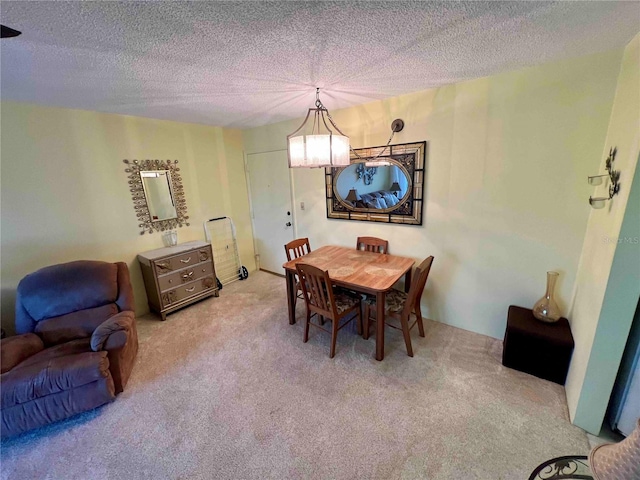 dining area with a textured ceiling, carpet floors, and an inviting chandelier