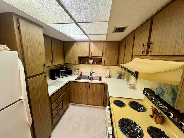 kitchen with sink, exhaust hood, and white appliances