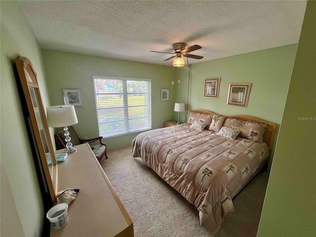 bedroom featuring ceiling fan, carpet flooring, and a textured ceiling